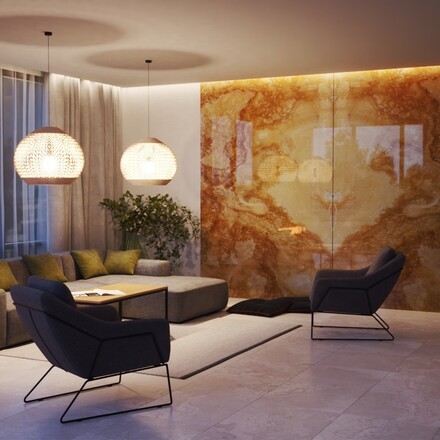 Přírodní kámen Onice Honey při nočním osvětlení - použití na obkladu stěny a krbu.