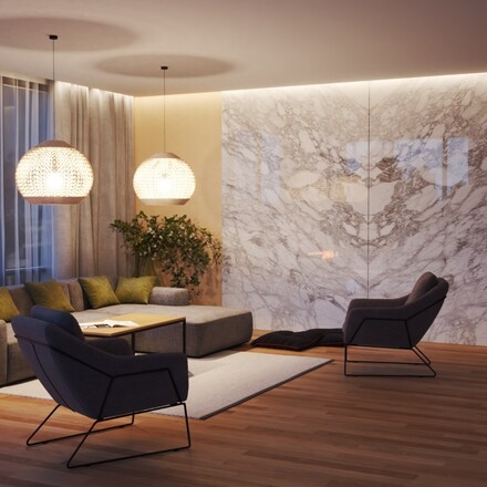 Noční scéna s obložením krbu přírodním mramorem Bianco Carrara a obkladem stěny s použitím techniky bookmatch.