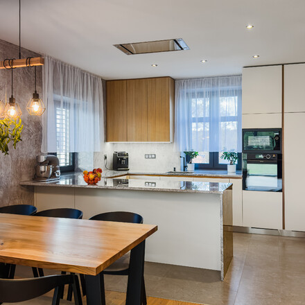 Kamenná kuchyňská deska z šedé žuly Kashmir Silver s kamenným obkladem boku ostrůvku. Kamenná kuchyňská deska z šedé žuly Kashmir Silver s kamenným obkladem boku ostrůvku.