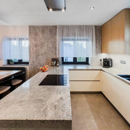 Kamenná pracovní deska z přírodní žuly Kashmir Silver v šedé barvě v moderním interiéru Kamenná pracovní deska z přírodní žuly Kashmir Silver v šedé barvě v moderním interiéru