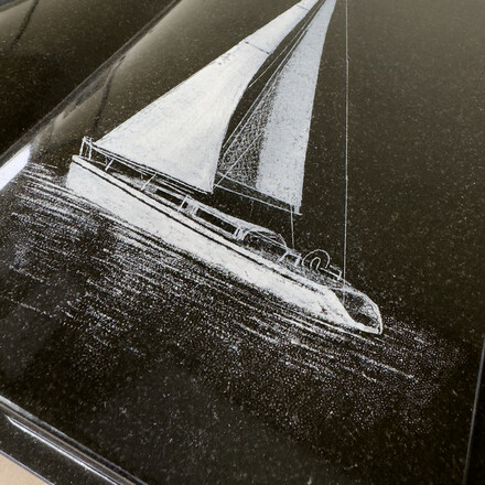 Motiv pískované plachetnice na žulové knize.