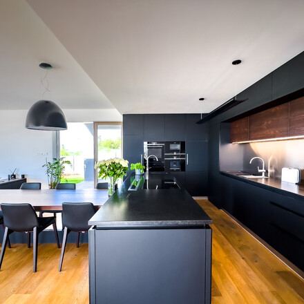 Designová kuchyň s černými skříňkami a černou žulovou pracovní deskou z přírodního kamene Nero Assoluto Zimbabwe s jemnou kartáčovanou povrchovou úpravou. Zakázková výroba TONE OF STONE.