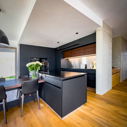 Modern&iacute; kuchyně v minimalistick&eacute;m stylu s kamennou kuchyňskou deskou ze žuly Nero Assoluto Zimbabwe s jemn&yacute;m kart&aacute;čovan&yacute;m povrchem. Zak&aacute;zkov&aacute; v&yacute;roba TONE OF STONE.