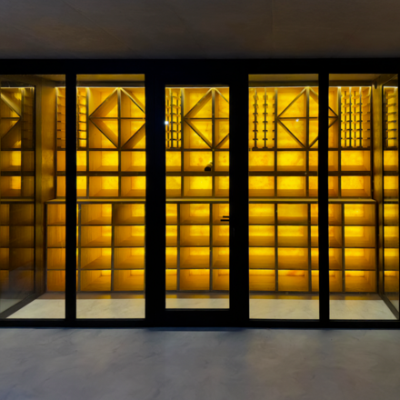 Obklad stěny vinotéky podsvíceným přírodním kamenem Onice Honey.