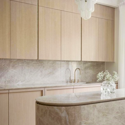 Kuchyňská linka z kvarcitu Taj Mahal v kombinaci s dřevěnými prvky působí harmonicky a nadčasově. Zakázkové kamenictví TONE OF STONE.