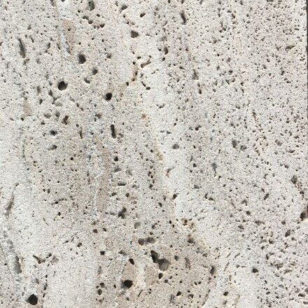 Detail pórovité struktury přírodního kamene Travertino Romano Classico.