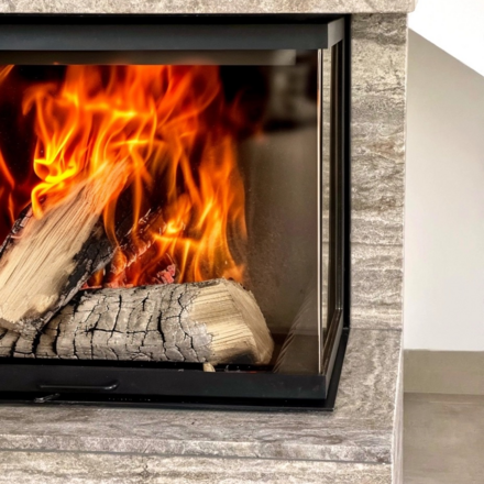 Kamenný obklad krbu z travertinu Travertino Silver dokáže akumulovat teplo krbu, které postupně uvolňuje zpět do místnosti