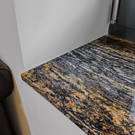 Tmav&yacute; kamenn&yacute; parapet ze žuly Magma Black se svou charakteristickou žilkovanou kresbou plnou čern&yacute;ch a zlat&yacute;ch t&oacute;nů