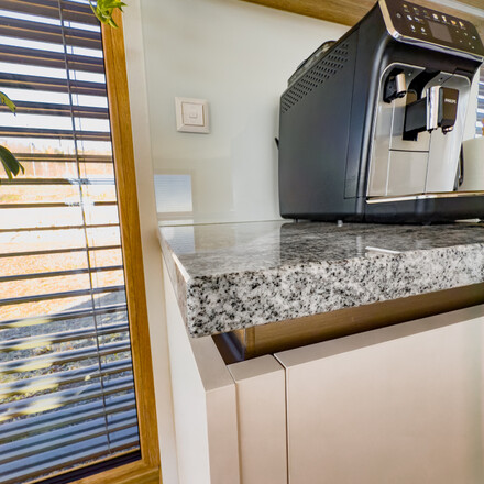 Precizní opracování hran kamenné kuchyňské desky ze žuly Viscount White. Pro tuto realizaci byl zvolen typ opracování H1.