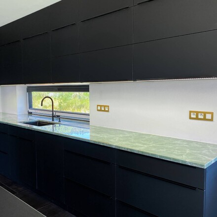 Kuchyňsk&aacute; deska z kvarcitu Jador v zelen&eacute;m odst&iacute;nu a leskl&eacute; povrchov&eacute; &uacute;pravě