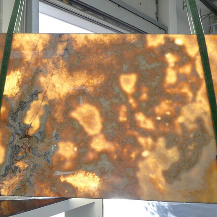 Poloprůsvitná deska z onyxu Onice Miele s jemným žilkováním, vhodná jako obklad stěny nebo kamenný stůl do moderního interiéru. Poloprůsvitná deska z onyxu Onice Miele s jemným žilkováním, vhodná jako obklad stěny nebo kamenný stůl do moderního interiéru.