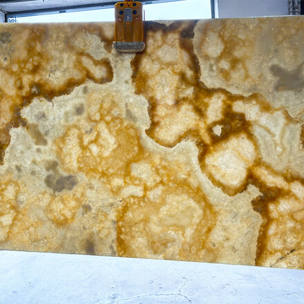 Prosvícená onyxová deska přírodního kamene Onice Miele v odstínech žluté, oranžové a bílé