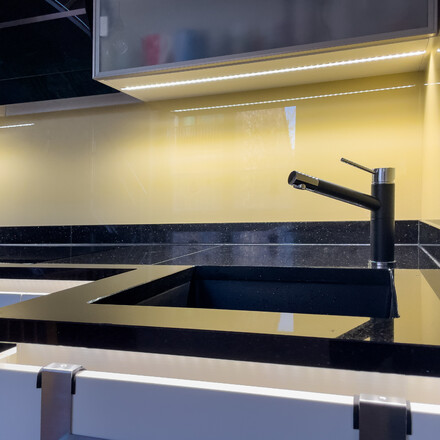 Kuchyňsk&aacute; pracovn&iacute; deska z př&iacute;rodn&iacute;ho kamene - le&scaron;těn&aacute; čern&aacute; žula s třpytiv&yacute;mi fragmenty - STAR GALAXY, detail baterie a spodn&iacute;ho dřezu