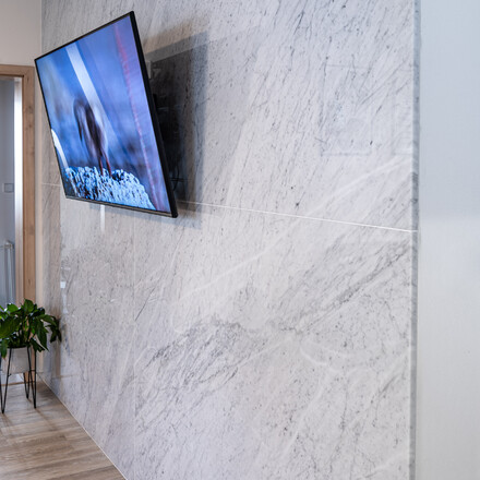 Obklad stěny z le&scaron;těn&eacute;ho mramoru Bianco Carrara, velk&eacute; desky na m&iacute;ru, kamenictv&iacute; Tone Of Stone