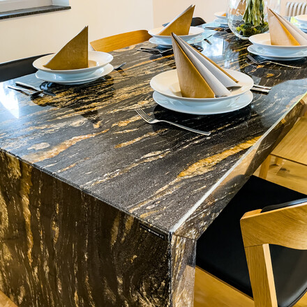 Velk&yacute; j&iacute;deln&iacute; stůl z exkluzivn&iacute; brazilsk&eacute; žuly MAGMA BLACK ve tvaru obr&aacute;cen&eacute;ho p&iacute;smene U se spodn&iacute;m zakryt&iacute;m, zak&aacute;zkov&aacute; v&yacute;roba kamenictv&iacute; TONE OF STONE.